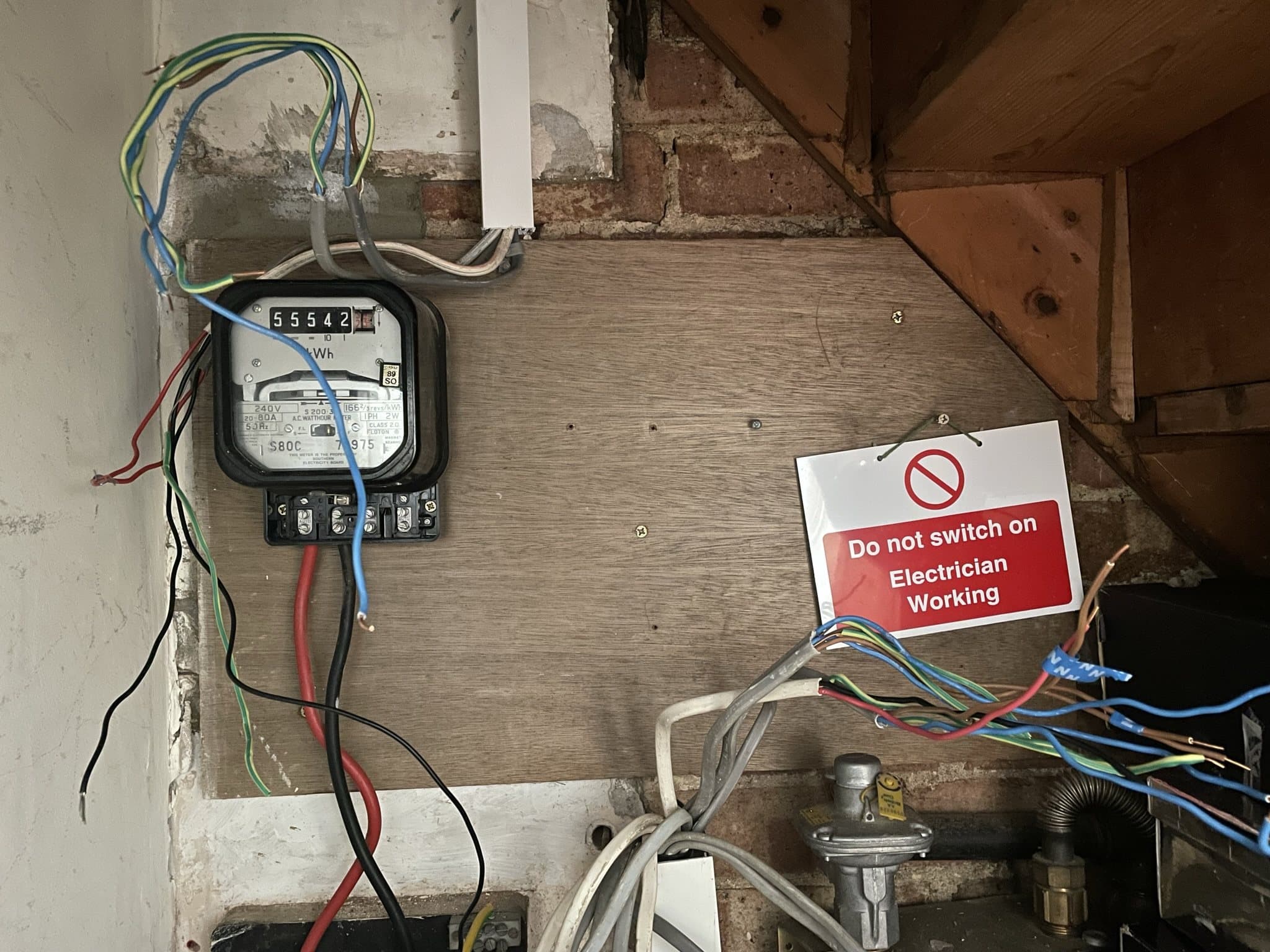 Old consumer unit removed from mounting board